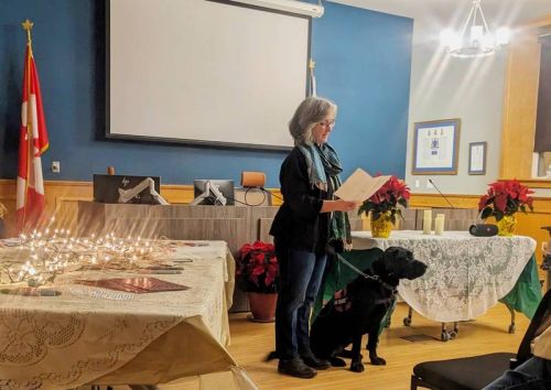 Jane New and her service dog, Seamus, reading “The Dash” and the second one is of the candles people brought up to the front.